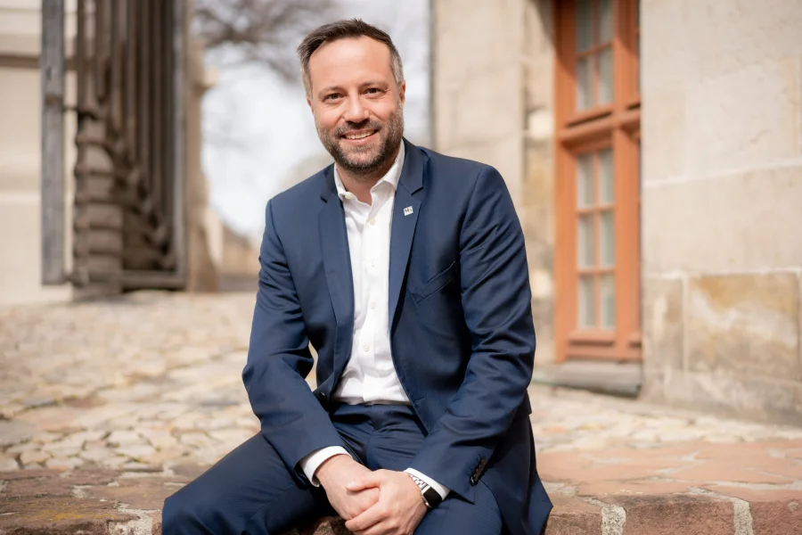 Hardy Puls bei einem Fotoshooting, im Hintergrund Blick auf den Eingang zum Haus der Romanik