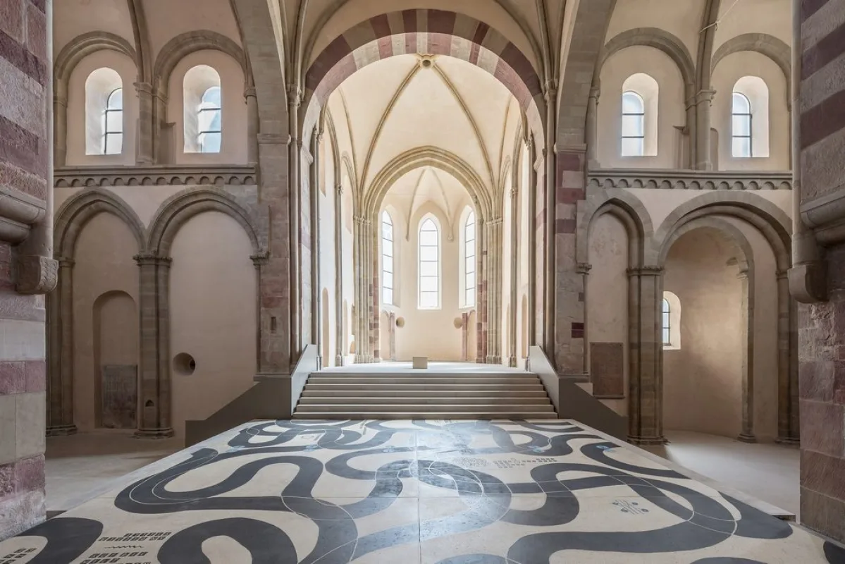 Blick durch die Klosterkirche Unser Lieben Frauen zum lichten Chor mit Treppenaufgang, im Vordergrund die geschwungene schwarz-wei&szlig;e Bodenarbeit