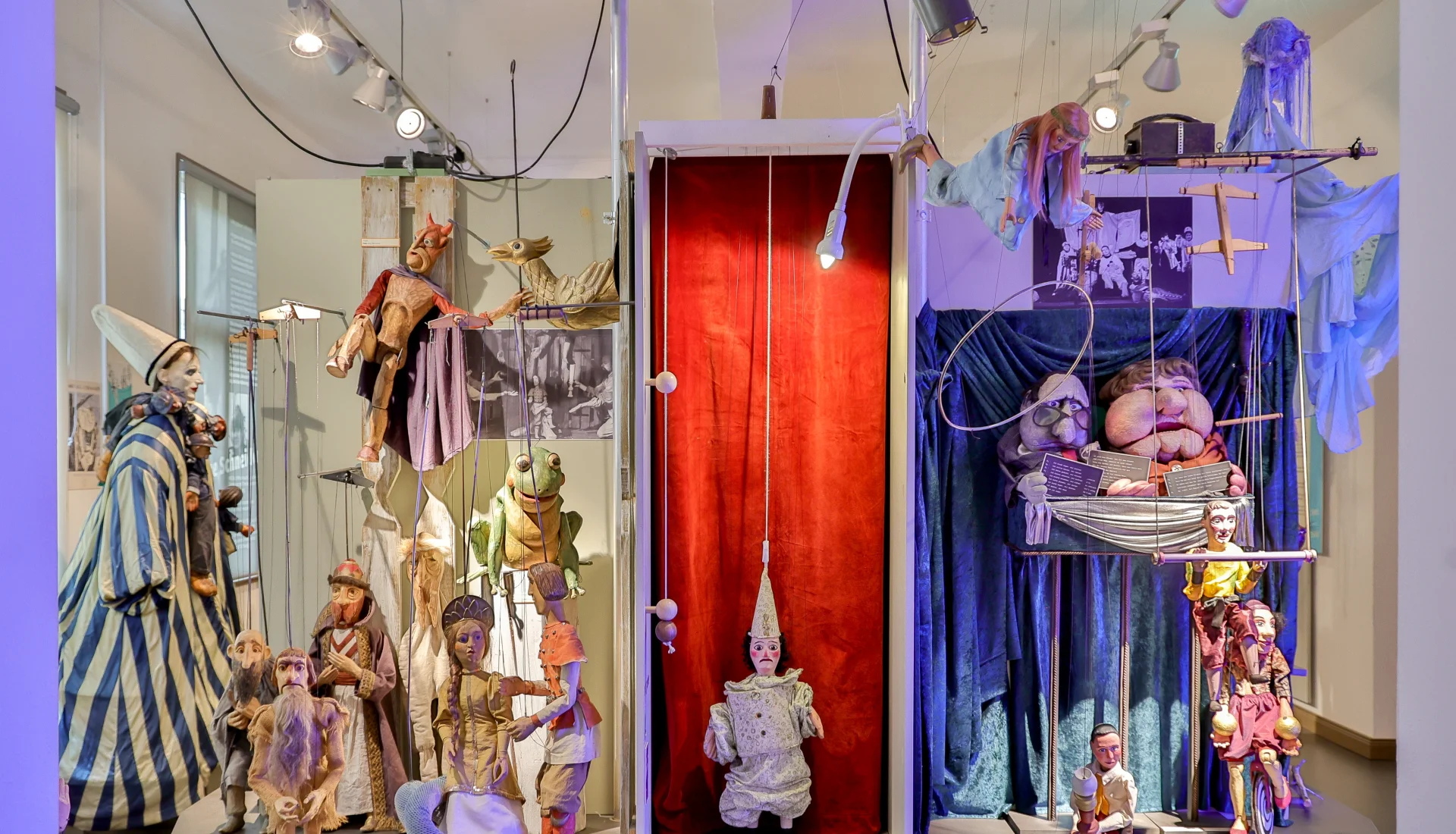 Blick in die Figurensammlung mit verschiedenen Handpuppen durch Lichtstrahler in Szene gesetzt