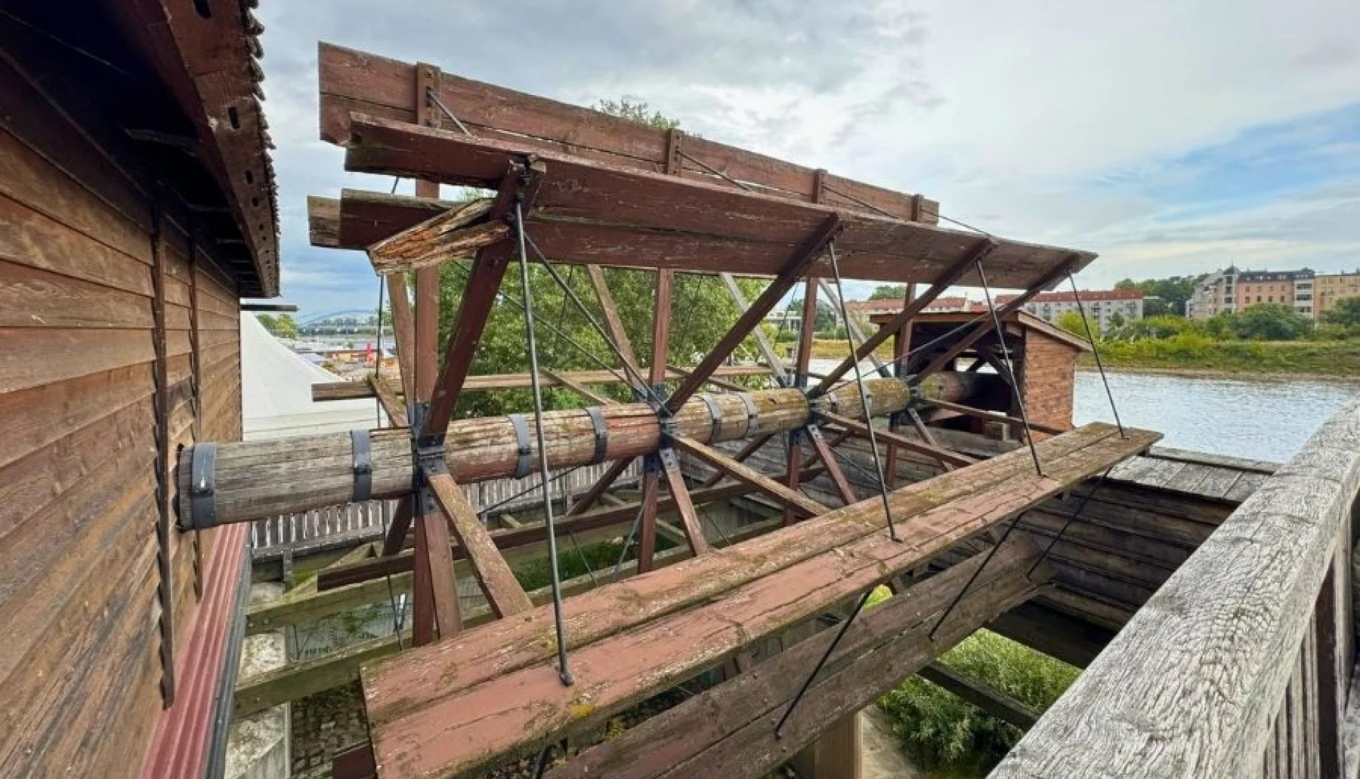Blick auf das alte M&uuml;hlrad aus Holz, im Hintergrund die Elbe