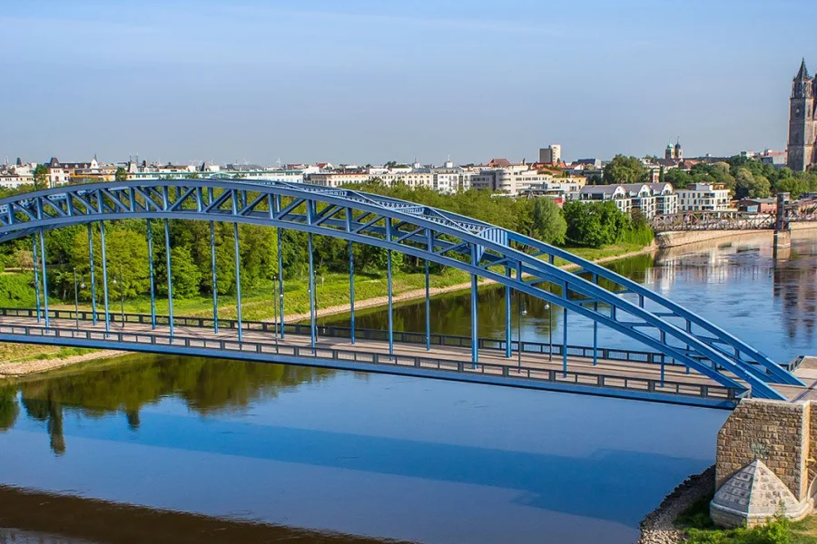Luftaufnahme der blauen Sternbruecke ueber der Elbe, rechts am Ufer Dom und Stadtsilhouette im Sommer