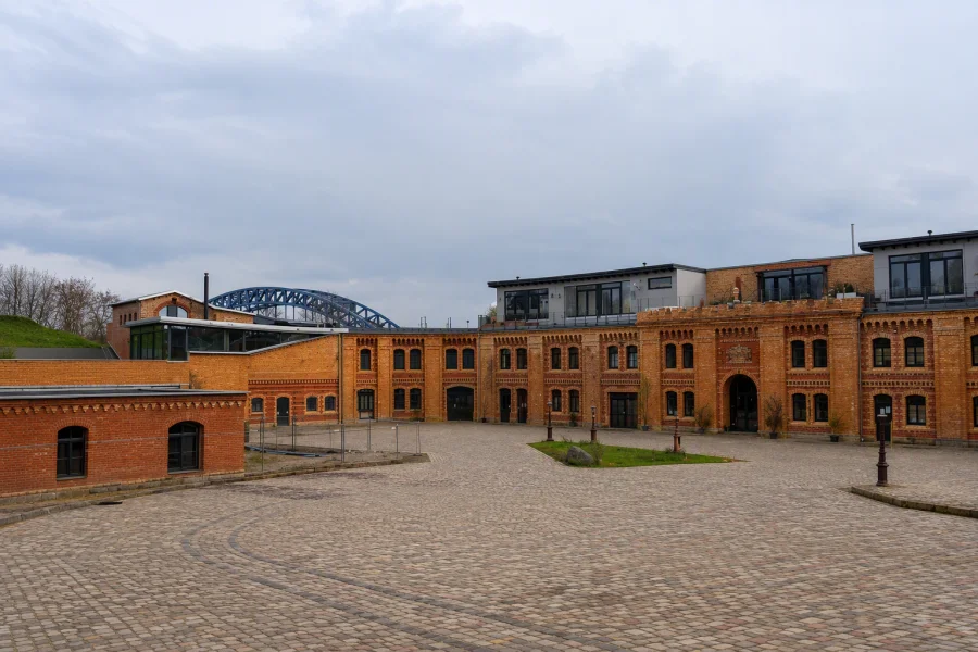 Blick auf das rote Gem&auml;uer de Festung Kavalier 1 "Scharnhorst", in der sich nun Wohnungen befinden. Im Hintergrund ein Teil der Sternbr&uuml;cke.