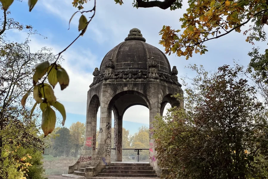 Blick auf den Venustempel am Adolf-Mittag-See mit &Auml;sten und Bl&auml;ttern im Vordergrund. Herbstliche Stimmung.