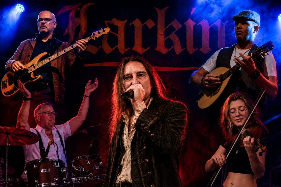 Bildmontage der Band Larkin auf der B&uuml;hne: Bassist, Schlagzeuger, S&auml;nger am Mikrofon, Bouzouki-Spieler und Geigerin vor dem Bandschriftzug